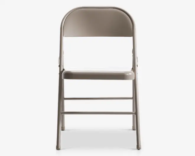 En sammenklappelig stol i metal med en lys grå finish. Stolen har et buet ryglæn og et fladt sæde, begge lavet af metal. Benene er lige og har to vandrette støttebjælker for ekstra stabilitet. Stolen er designet til at kunne foldes sammen for nem opbevaring og transport.