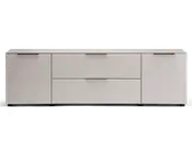 Et moderne, lavt opbevaringsmøbel med mat lysegrå finish. Det har to store skuffer i midten og et skab med låge i hver side, alle med slanke, vandrette metalhåndtag. Designet er minimalistisk med rene linjer og en flad top, der egner sig til at udstille genstande eller placere elektronik på.