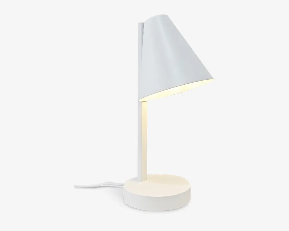 En moderne, minimalistisk lampe med mat hvid finish. Lampen har en konisk lampeskærm, der er vinklet nedad, fastgjort til en lige, lodret stang og en rund, solid fod. Der er en synlig ledning, der går ud fra foden, og lyset spredes blødt ud under skærmen, hvilket gør lampen velegnet til skrivebord eller natbord.