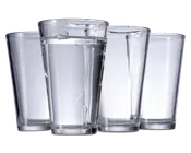 Sæt med fire klare, cylindriske drikkeglas med let konisk form, bredere foroven og smallere forneden. Glassene har en glat overflade og en tyk, solid bund for stabilitet. Ét glas er fyldt med vand, mens de tre andre er tomme.