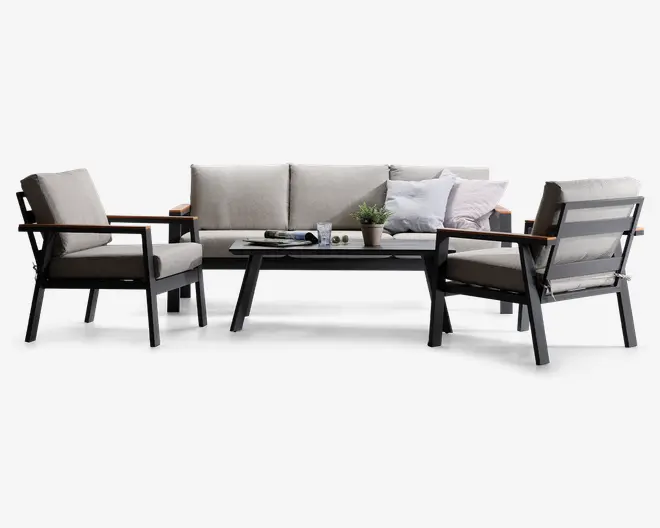 Moderne udendørs loungesæt bestående af en trepersoners sofa og to loungestole med lyse beige hynder. Stellet er lavet af mørkt metal med trædetaljer på armlænene. Sættet inkluderer et rektangulært sofabord med glat overflade, pyntet med en potteplante, et glas, en bog og to små dekorative genstande. Hynderne ser tykke og komfortable ud, og designet er stilrent og moderne.