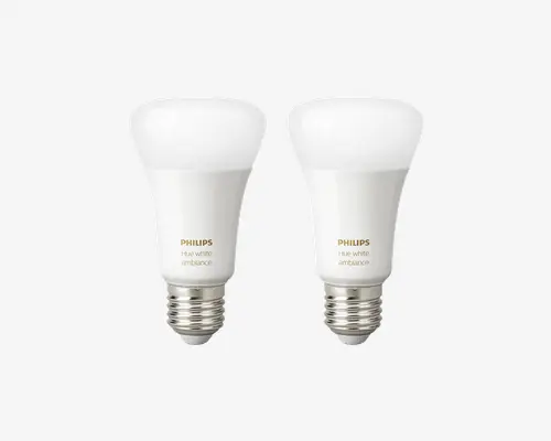 Sæt med to smarte LED-pærer med standard E26-sokkel. Hver pære har en mat hvid finish og en afrundet top. Pærerne er mærket 'Philips Hue white ambiance' og er designet til justerbart hvidt lys, så du kan vælge mellem forskellige nuancer fra varmt til koldt. Pærerne har et moderne, slankt design og er kompatible med smart home-systemer til fjernstyring og automatisering.