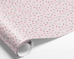 Billedet viser en rulle papir med et festligt mønster. Baggrunden er en blød pastelpink, og designet har små illustrationer af rød- og hvidstribede slikstokke, pebermyntebolsjer og grønne grene af kristtorn og fyr. Mønstret er jævnt fordelt og gentages over hele overfladen, hvilket giver et muntert og julet udtryk.
