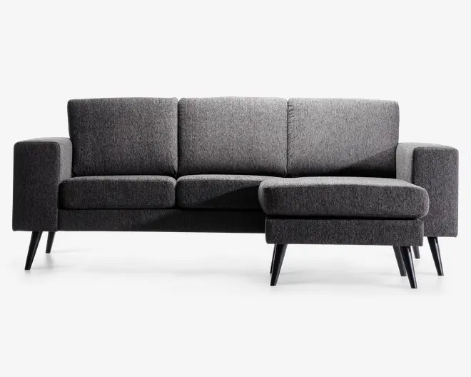 Moderne hjørnesofa betrukket med mørkegråt stof og højrevendt chaiselong. Sofaen har rene linjer, tre ryghynder og brede armlæn. Den står på skrå, koniske træben i mørk finish, hvilket giver et retro-inspireret udtryk. Sædehynderne er tykke og faste for god støtte.