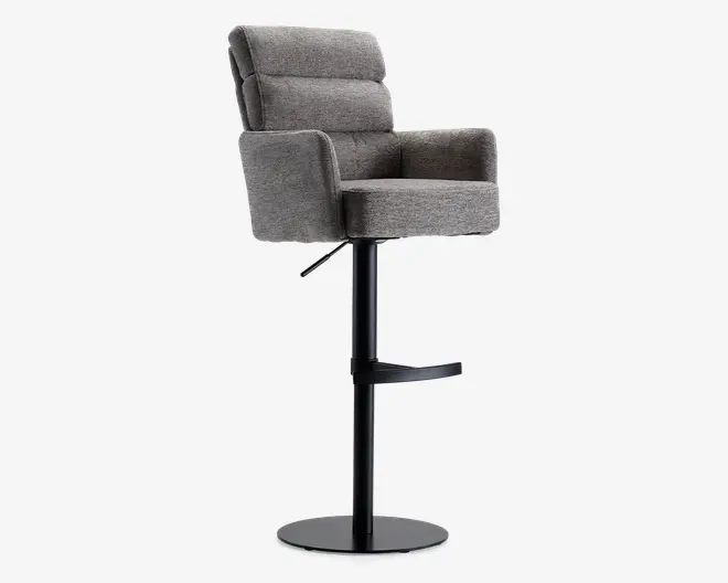 En moderne barstol med blødt, gråt polstret sæde og ryglæn, der har vandrette syninger for ekstra komfort. Stolen har armlæn og en robust sort metalfod med rund fodstøtte for støtte. Det samlede design er stilrent og moderne, velegnet til køkkenøer eller hjemmebarer.
