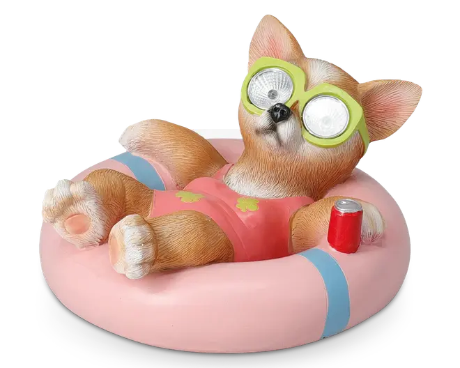 En dekorativ figur af en afslappet hund iført lyserød badedragt og grønne solbriller, der ligger på en lyserød og blå oppustelig badering. Hunden har realistisk pelsstruktur, store spidse ører og holder en rød sodavandsdåse. Solbrillerne har reflekterende linser, hvilket giver et sjovt udtryk.