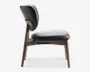 Sidebillede af en stol med polstret sæde og ryglæn betrukket med glat, mørkt materiale. Stolen har en solid træramme med skråtstillede ben og et buet ryglæn, hvilket giver både komfort og moderne stil. Sædet og ryglænet er godt polstrede, og træet har en naturlig finish.