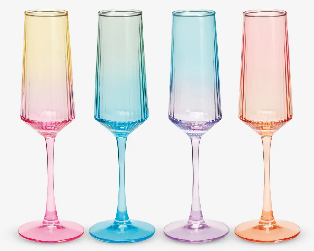 Sæt med fire høje, slanke glas med riflet design og farvede gradient-stilke og bunde. Hvert glas har en forskellig pastel farve: pink, blå, lilla og orange. Glassets skål er klar øverst og går gradvist over i farven ved bunden, hvilket giver et moderne og elegant udtryk.