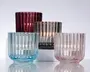 Sæt med fire lysestager i glas med lodret rillet tekstur. Hver lysestage har en forskellig farve: mørkerød, røggrå, lyseblå og lyserød. Glasset er tykt og robust med en rund bund og lige sider. Det rillede design giver en glitrende effekt, når lysene er tændt indeni, hvilket tilføjer elegance og visuel interesse. Passer til fyrfadslys.