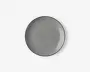 Rund tallerken med en glat, blank overflade i ensfarvet grå. Tallerkenen har en let forhøjet kant og et minimalistisk design, der passer til moderne borddækning.