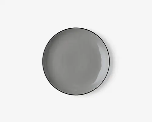 Rund tallerken med en glat, blank overflade i ensfarvet grå. Tallerkenen har en let forhøjet kant og et minimalistisk design, der passer til moderne borddækning.