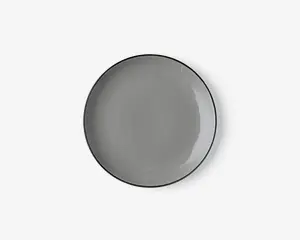 Rund tallerken med en glat, blank overflade i ensfarvet grå. Tallerkenen har en let forhøjet kant og et minimalistisk design, der passer til moderne borddækning.