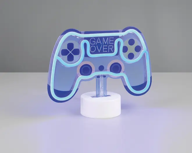 En dekorativ LED-lampe formet som en videospil-controller med blå konturer og oplyste detaljer. Lampen har en hvid, rund base og viser teksten 'GAME OVER' i midten. Designet inkluderer knapper og joystick-detaljer, hvilket gør den velegnet til gaming-inspireret indretning.