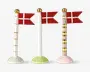 Sæt med tre dekorative flagstænger, hver med et rødt flag med hvidt skandinavisk kors. Flagstængerne er lavet af keramik og har forskellige designs: én med gyldne vandrette striber og hvid fod, én med små grønne prikker og lysegrøn fod, og én med skiftevis gyldne og hvide striber samt lyserød fod. Alle flagstænger har en gylden kugle på toppen.