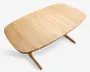 Rektangulært bord i lyst egetræ med blødt afrundede hjørner og en glat overflade. Bordpladen har en diskret samling i midten, hvilket tyder på, at det kan udvides. Benene er let skrå og afrundede, hvilket giver et moderne og minimalistisk udtryk.