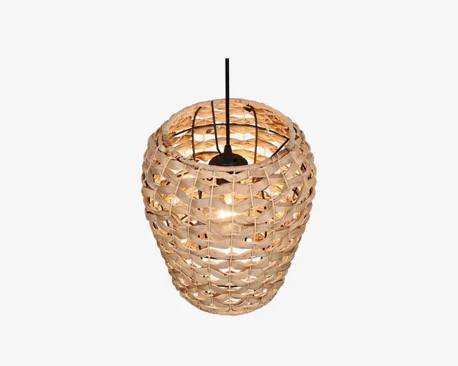 Hængelampe med en skærm flettet af rattan i en naturlig beige farve. Skærmen har et åbent, kurvelignende design, der lader lyset trænge igennem og skaber en varm og hyggelig stemning. Lampen hænger i en sort ledning, og pæren er synlig indeni, hvilket giver et rustikt og moderne udtryk.
