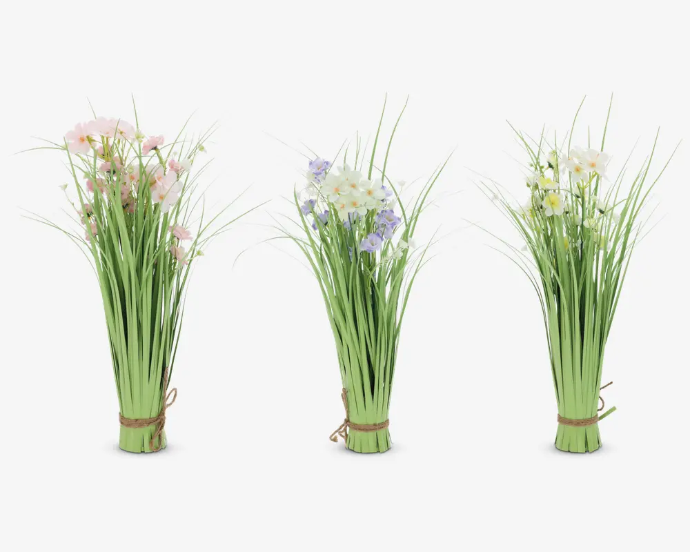 Tre bundter kunstige blomster med lange grønne stilke og blade, hver bundet sammen i bunden med snor. Blomsterne har sarte pastelfarver: ét bundt med lyserøde blomster, ét med hvide og lyse lilla blomster, og ét med hvide og gule blomster. Arrangementet er højt og slankt med et naturligt, vildblomst-udseende.