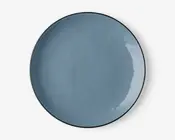 En rund, flad tallerken med en glat, blank overflade i en afdæmpet blå farve. Tallerkenen har en let hævet kant og et minimalistisk, moderne design. Overfladen er jævn og reflekterende med diskrete variationer i glasuren, som giver karakter.