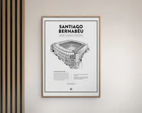 En indrammet plakat med en detaljeret sort-hvid arkitektonisk illustration af Santiago Bernabéu-stadionet. Plakaten har stadionets navn med store bogstaver øverst, efterfulgt af oplysninger som placering, åbningsdato og kapacitet. Under illustrationen er der en tekstblok med beskrivelse og statistik om stadionet. Rammen er enkel og lavet af lyst træ, og plakaten har et minimalistisk design med hvid baggrund og en tynd sort kant.