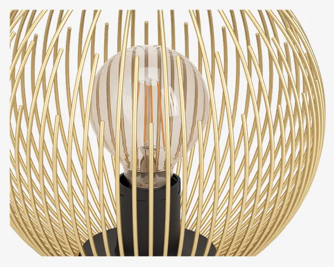 Nærbillede af en dekorativ lampe med en klar rund pære, hvor filamenterne er synlige, omgivet af et kugleformet bur lavet af snoede metalstænger i guldfarve. Pærens sokkel er sort, hvilket giver en kontrast til det metalliske bur. Designet er moderne og elegant, og det åbne bur lader lyset skinne frit igennem.