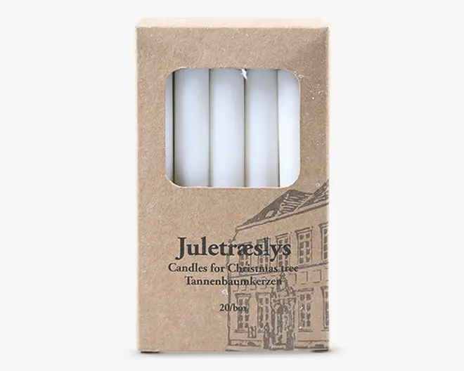 Æske med 20 slanke, hvide lys, synlige gennem et rektangulært vindue på forsiden. Emballagen er lavet af brun pap med sort trykt tekst og en illustration af en bygning. Teksten på æsken angiver, at det er juletræslys.
