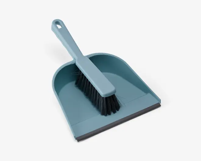 Et lyseblåt fejebakke- og kostesæt. Fejebakken har en bred, flad bund med let hævede sider og bagkant, samt en gummikant foran for bedre kontakt med gulvet. Den tilhørende kost har et solidt plastikgreb og tætte sorte børstehår, og passer perfekt ned i fejebakken for nem opbevaring.