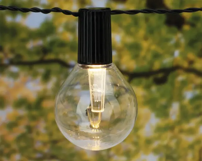 En klar, rund pære med synlig LED-filament indeni, hængende fra en sort plastiksokkel, der er fastgjort til en snoet sort ledning. Pæren udsender et varmt hvidt lys og er velegnet til udendørs eller dekorativ brug.