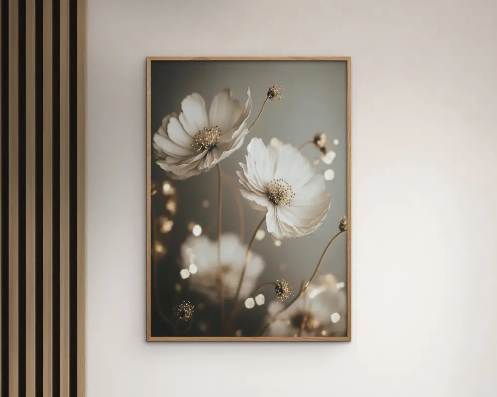 Et indrammet vægkunsttryk med et nærbillede af sarte hvide blomster med gule midter og slanke stilke, sat mod en blød, sløret baggrund i dæmpede grå og beige nuancer. Billedet har en drømmende bokeh-effekt med lyspunkter, hvilket giver det et elegant og moderne udtryk. Rammen er tynd og i træ, hvilket passer til det neutrale farveskema.