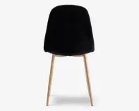 Stol med glat, sort, buet ryg og sæde, der har fire skråtstillede ben i lyst træ. Designet er minimalistisk og moderne med et blødt, polstret udseende på sæde og ryg.