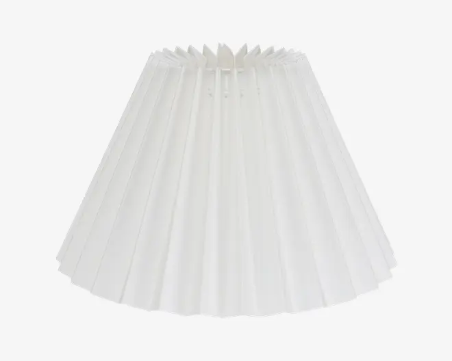 Hvid plisseret lampeskærm med konisk form og jævnt fordelte lodrette folder. Stoffet virker let og en smule gennemsigtigt, hvilket giver en blød lysspredning. Åbningen foroven er mindre end forneden, og der er en synlig indvendig ramme øverst, som støtter skærmen.