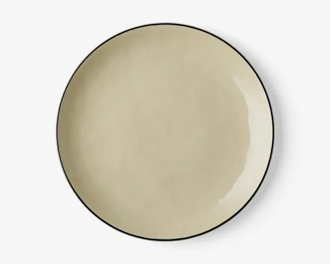 Rund tallerken med en glat, mat beige overflade og en tynd, mørk kant langs kanten. Designet er minimalistisk og moderne med en let ujævn finish, der giver et håndlavet udtryk.