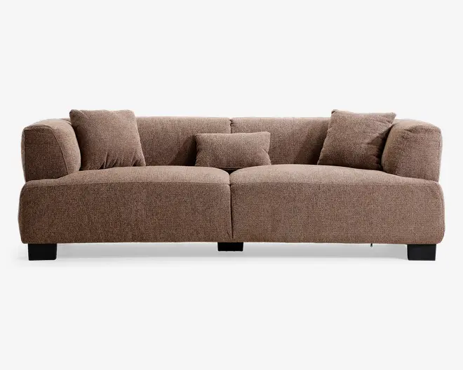 En lav brun sofa med polstret betræk, afrundede armlæn, to store sædehynder, tre ryghynder, en lille lændepude i midten og korte mørke ben.