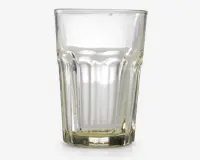 Klar glastumbler med facetslebet design, der har lodrette riller rundt om siderne for bedre greb. Glasset har en tyk, robust bund og udvider sig let mod kanten, hvilket giver et klassisk og praktisk udseende, der egner sig til daglig brug.