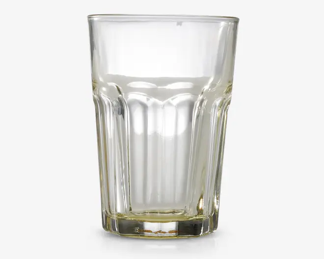 Klar glastumbler med facetslebet design, der har lodrette riller rundt om siderne for bedre greb. Glasset har en tyk, robust bund og udvider sig let mod kanten, hvilket giver et klassisk og praktisk udseende, der egner sig til daglig brug.