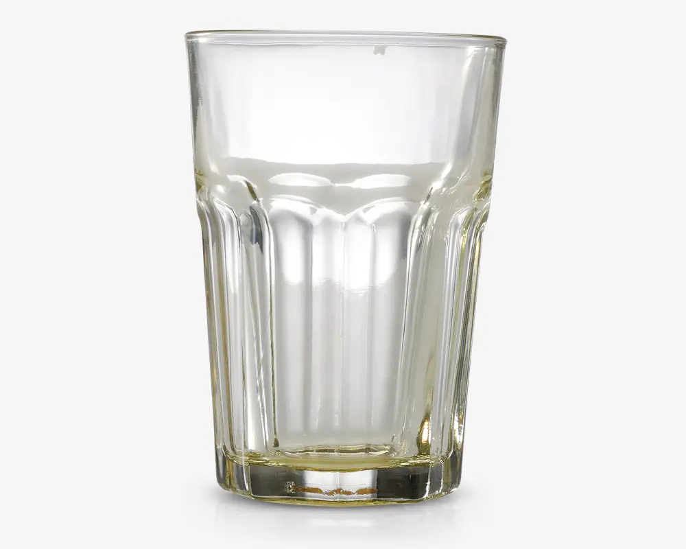 Klar glastumbler med facetslebet design, der har lodrette riller rundt om siderne for bedre greb. Glasset har en tyk, robust bund og udvider sig let mod kanten, hvilket giver et klassisk og praktisk udseende, der egner sig til daglig brug.