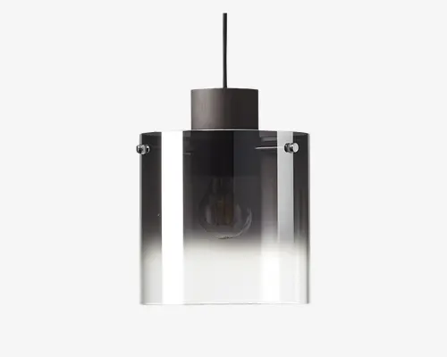 En moderne pendellampe med en cylindrisk glasskærm, der har en farveovergang fra mørk i toppen til klar i bunden. Lampen har en metalfatning og en synlig pære indeni, hvilket giver et stilrent og minimalistisk udtryk.