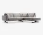 Moderne L-formet hjørnesofa med chaiselong til højre, betrukket med lysegråt stof. Sofaen har brede, dybe sæder og bløde ryghynder for ekstra komfort. Designet er enkelt med rene linjer og lave sorte ben, hvilket giver et moderne udtryk. Leveres med fem matchende ryghynder for øget støtte.