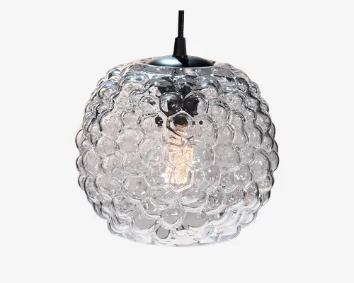 Kugleformet pendellampe med en klar glasskærm, der har en tekstureret overflade med boblelignende mønster. Glasset er tykt og gennemsigtigt, så pæren indeni er synlig. Lampen hænger i en sort ledning og har en metalhætte i toppen for et moderne udtryk.
