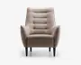 Frontvisning af en moderne lænestol med lysebeige stofbetræk. Stolen har en høj, let tilbagelænet ryg med vandrette kanalsyninger, der giver ekstra komfort og stil. Armlænene er vinklet udad og skaber et moderne udtryk. Sædepuden er tyk og blød, og stolen står på fire koniske sorte træben.
