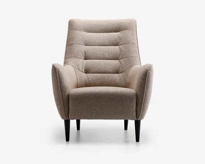 Frontvisning af en moderne lænestol med lysebeige stofbetræk. Stolen har en høj, let tilbagelænet ryg med vandrette kanalsyninger, der giver ekstra komfort og stil. Armlænene er vinklet udad og skaber et moderne udtryk. Sædepuden er tyk og blød, og stolen står på fire koniske sorte træben.