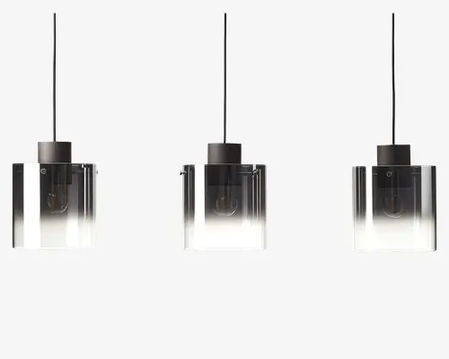 Sæt med tre pendellamper med firkantede, klare glasskærme, der har en gradient fra gennemsigtig i toppen til mat hvid i bunden. Hver lampe har en sort metalfatning og sort ledning til ophæng. Pærerne er synlige gennem glasset, hvilket giver et moderne og minimalistisk udtryk.