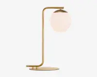 En moderne bordlampe med en slank metalramme i guldfinish og et vinkelret design. Lampen har en rund, flad fod og en lodret stang, der buer i toppen for at holde en stor, mat hvid glaskuppel. Kuppelen er delvist dækket af en gylden top, hvilket giver lampen et elegant og nutidigt udtryk.