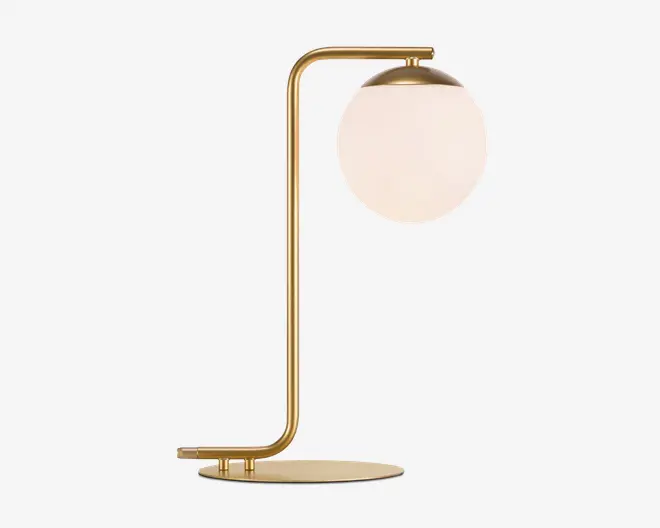 En moderne bordlampe med en slank metalramme i guldfinish og et vinkelret design. Lampen har en rund, flad fod og en lodret stang, der buer i toppen for at holde en stor, mat hvid glaskuppel. Kuppelen er delvist dækket af en gylden top, hvilket giver lampen et elegant og nutidigt udtryk.