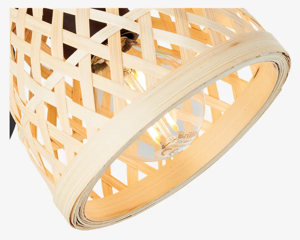 Nærbillede af en lampeskærm flettet af bambus i en lys, naturlig træfarve. Skærmen har et krydsmønstret gitterdesign, der lader lyset slippe igennem åbningerne. Indeni er der en klar glødepære med synlige filamenter, som giver et varmt og hyggeligt lys. Lampeskærmens kant er forstærket med et tykkere, glat bambusbånd for ekstra holdbarhed og et elegant udtryk.