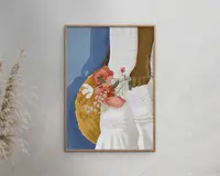 Indrammet kunstværk med en nærbillede-illustration af en person med mørk hud iført en hvid broderet kjole. Personen holder en buket med lyserøde og hvide blomster samt en rund stråtaske. Baggrunden er blød blå, og rammen er i lyst træ.