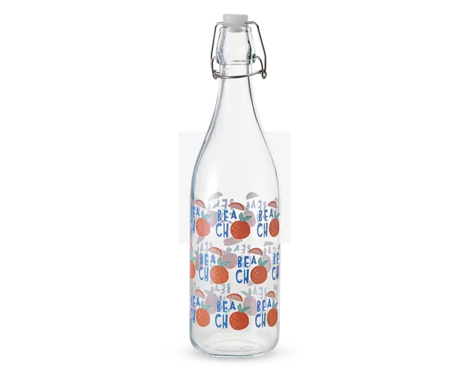 Klar glasflaske med metal-låg med svinglås, dekoreret med et gentagende mønster af appelsinillustrationer og ordet 'BEACH' med blå bogstaver. Flasken har en glat, cylindrisk form, og designet giver et legende, sommerligt udtryk.