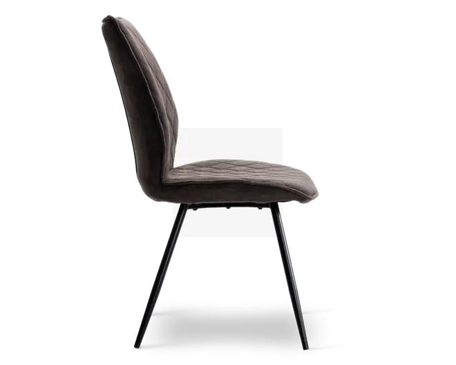 Sidebillede af en stol med blødt, mørkt polstret sæde og ryglæn med diskrete lodrette syninger. Stolen har et let buet ryglæn for ergonomisk støtte og står på fire slanke, skråtstillede metalben med mat sort finish.