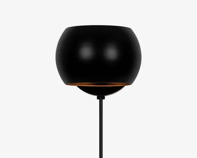 En moderne lampe med en mat sort, rund skærm, der har en let åben bundkant med en diskret gylden indvendig detalje. Lampen har et slankt, minimalistisk design med en lige, tynd sort stander.