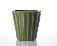 En grøn keramisk beholder med blank overflade og lodrette riller. Siderne er let koniske, bredere foroven og smallere forneden, hvilket giver et moderne og elegant udtryk.
