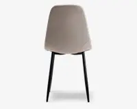 Stol med glat, lysebeige polstret ryg og sæde, med diskrete syninger nær de nederste hjørner. Stolen har fire slanke, sorte metalben, der er let udadskrånende for stabilitet.